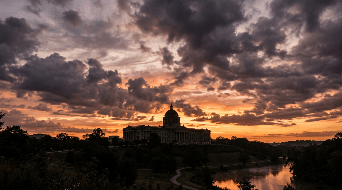 Capitol building silhouette at sunset with colorful sky and river